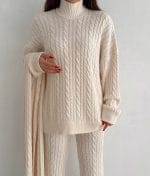 Coordinated cable knit scarf styled with sweater and pants