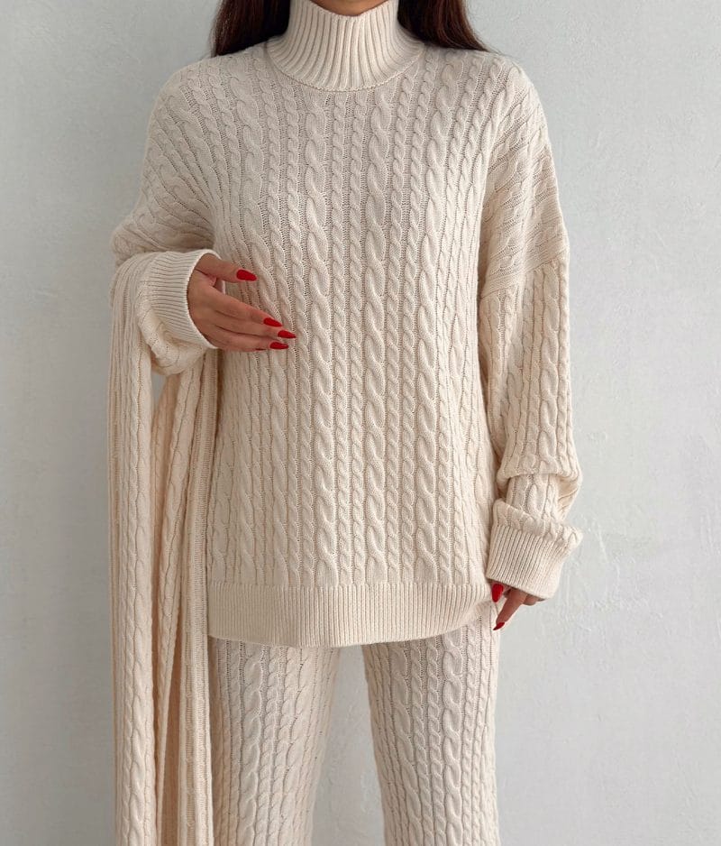 Coordinated cable knit scarf styled with sweater and pants
