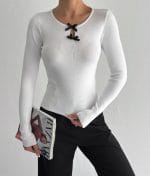 White knit top featuring black bow accents on keyhole neck
