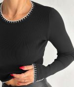 Close-up of crew neck black knit top with contrast stitch trim for stylish wholesale collections.