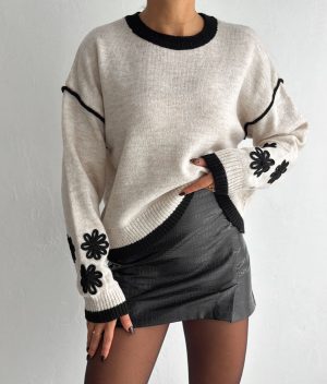 Women’s beige sweater featuring black flower embellishments