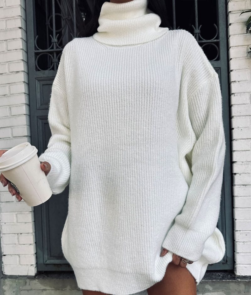 model holding coffee cup wearing knit turtleneck sweater dress