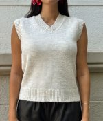 model wearing sleeveless v-neck knit vest with black trousers