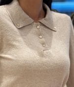 Women’s beige polo knit top with pearl buttons close up